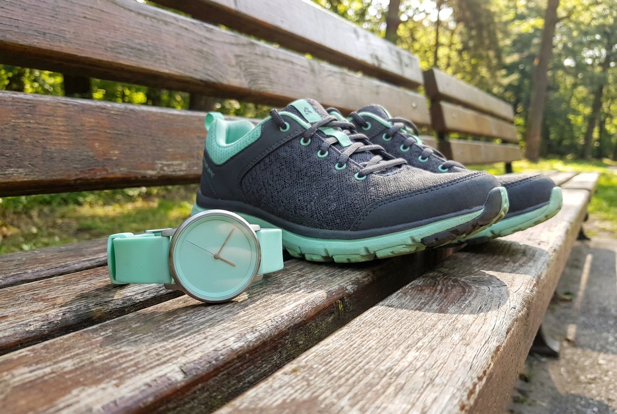 Eenvoudige stappenteller naast wandelschoenen op een houten bankje
